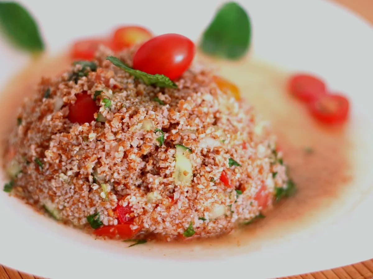 Delicious tabbouleh salad featuring fresh tomatoes, mint, and bulgur wheat served on a plate.